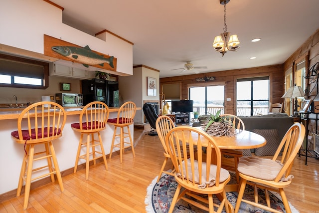 dining area with light wood-type flooring, ceiling fan with notable chandelier, and recessed lighting