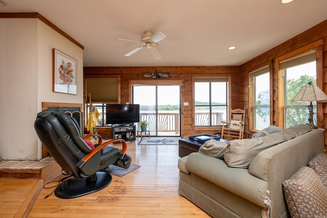 living area with ceiling fan, wooden walls, light wood-type flooring, and recessed lighting