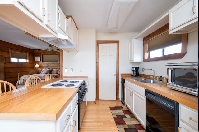 kitchen with butcher block countertops, white cabinets, a sink, and black appliances