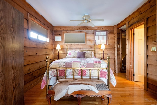 bedroom featuring light wood-type flooring and wooden walls