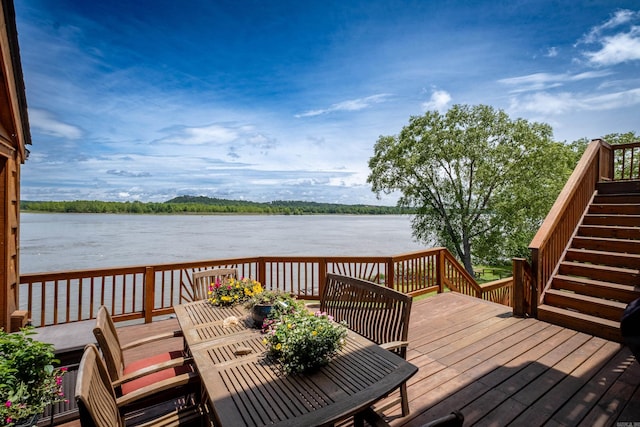 deck with a water view, stairway, and outdoor dining space