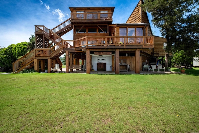 rear view of house featuring a patio area, stairway, a lawn, and a wooden deck