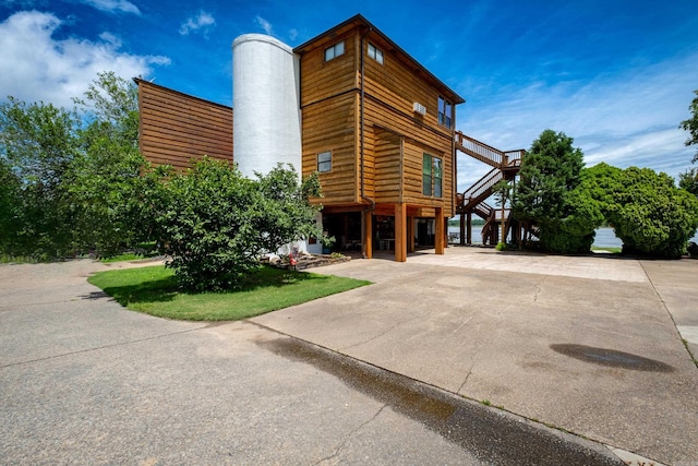 view of building exterior with driveway and stairs