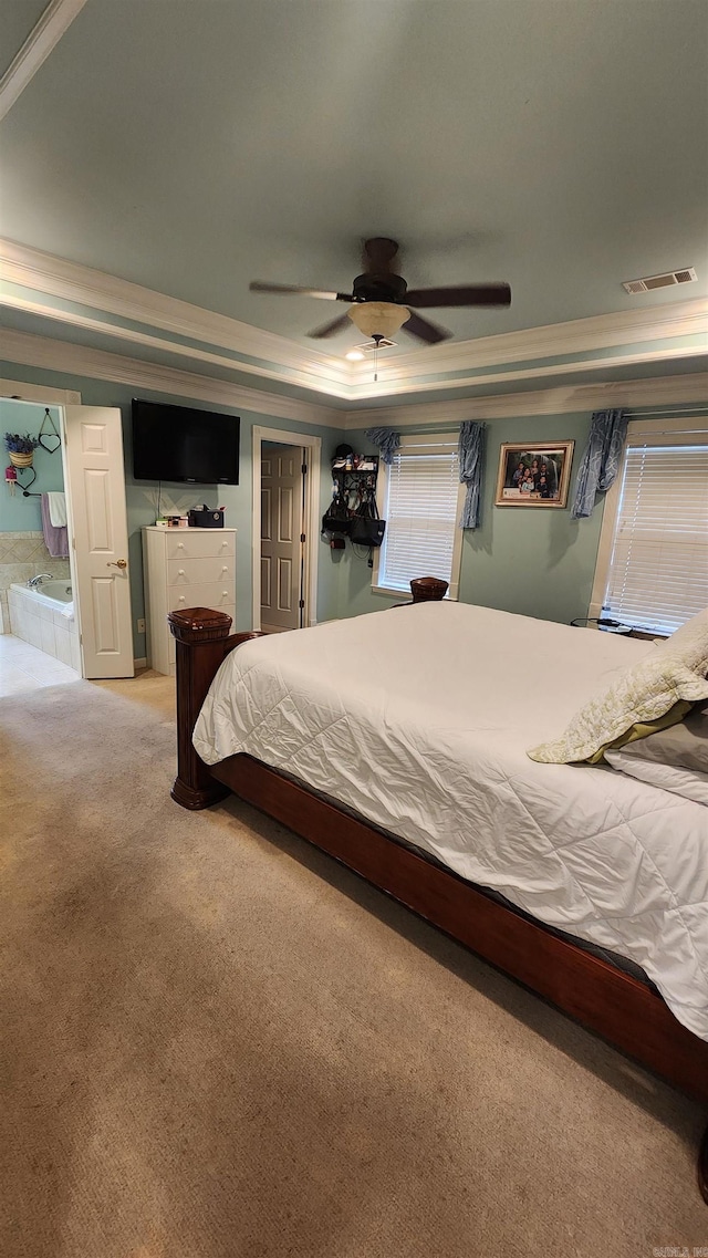 bedroom featuring light carpet, visible vents, a raised ceiling, and a ceiling fan