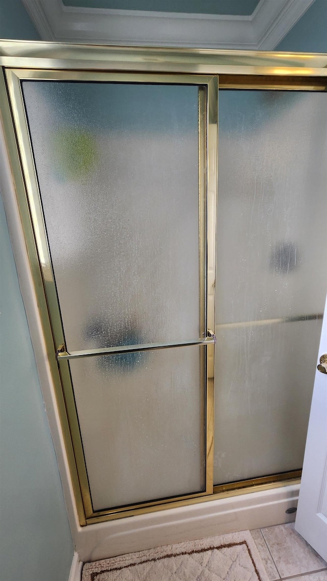 bathroom featuring a shower with door, ornamental molding, and tile patterned floors