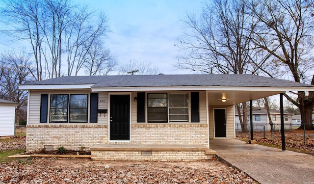 view of front of house with brick siding, covered porch, fence, an attached carport, and driveway