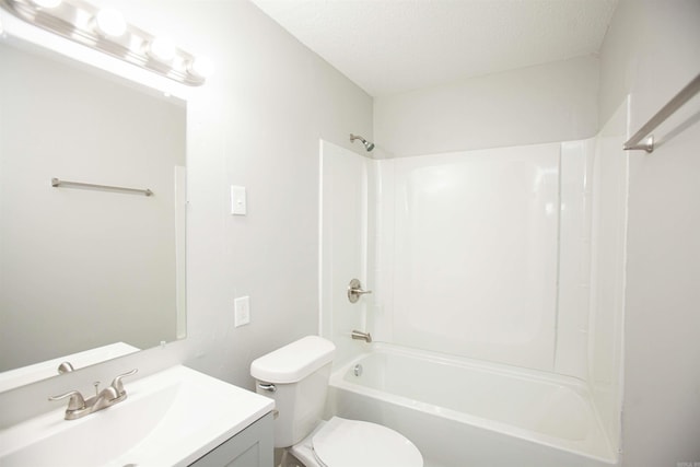 full bath with a textured ceiling, vanity, bathtub / shower combination, and toilet