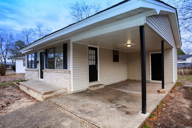 exterior space with a carport and brick siding