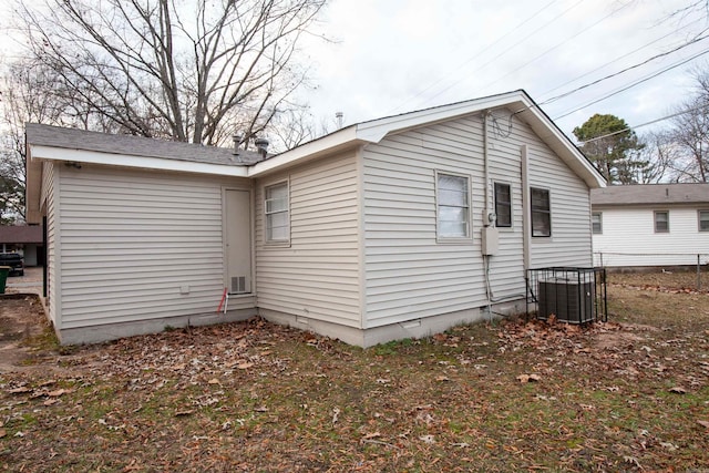 rear view of property with crawl space and central AC