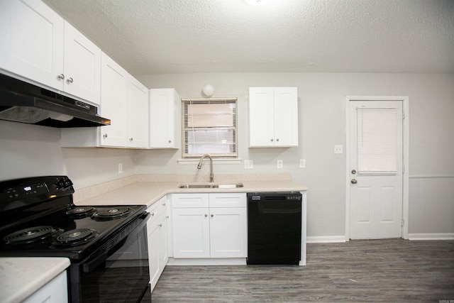 kitchen featuring under cabinet range hood, wood finished floors, a sink, white cabinets, and black appliances