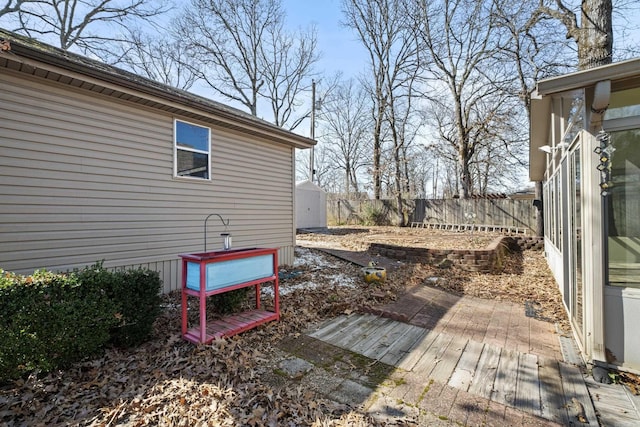 view of yard featuring fence private yard, a deck, and an outbuilding