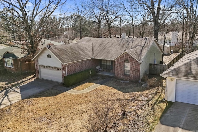 single story home with a garage, fence, concrete driveway, and brick siding