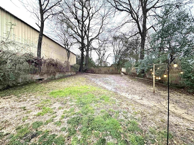 view of yard featuring driveway and fence