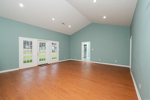 875 Ouachita 64, Camden, AR 71701 - spare room with baseboards, a textured ceiling, wood finished floors, and high vaulted ceiling