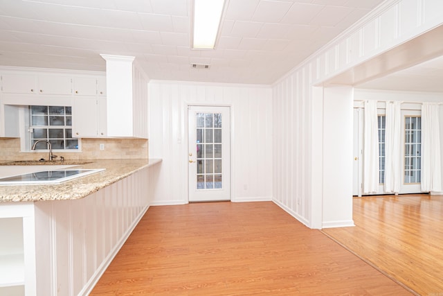 kitchen featuring visible vents, light wood-style flooring, ornamental molding, white electric cooktop, and white cabinetry