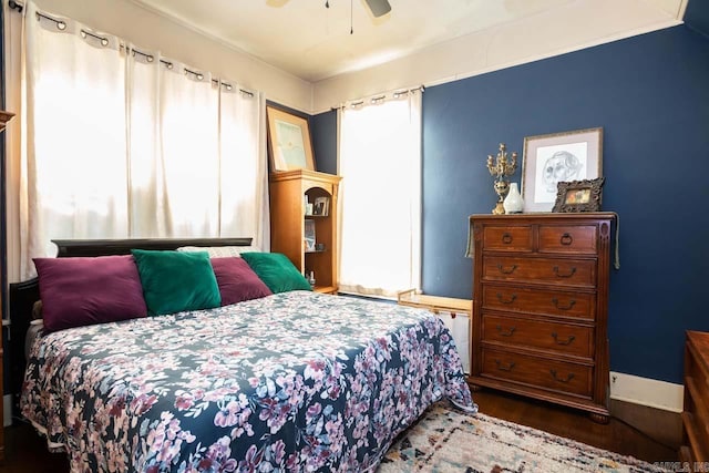 bedroom with a ceiling fan, baseboards, and wood finished floors