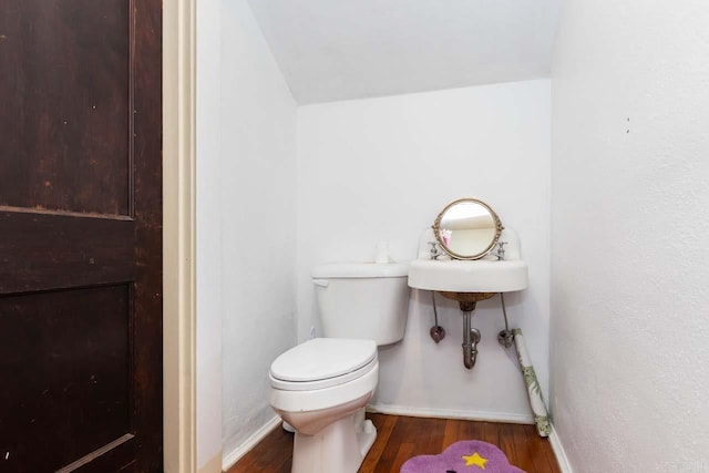 bathroom featuring baseboards, toilet, and wood finished floors