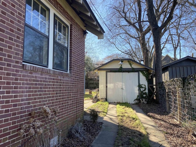 view of side of property with brick siding, an outdoor structure, fence, and a shed