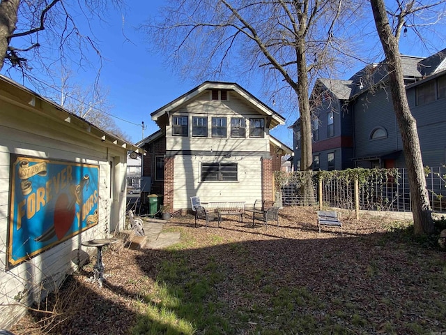 back of house with fence and brick siding