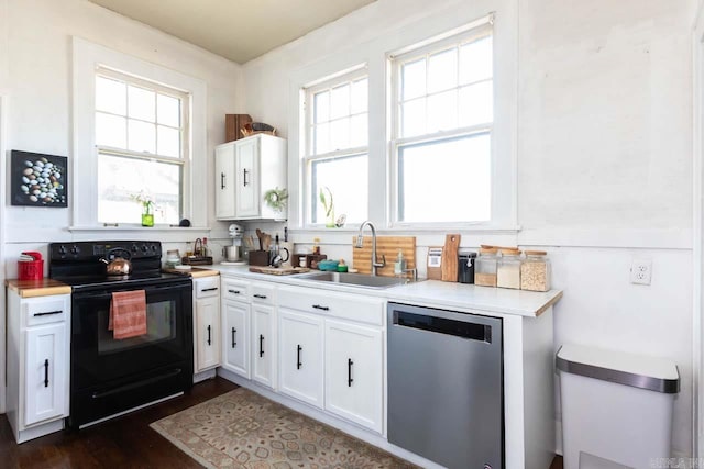 kitchen featuring black electric range, stainless steel dishwasher, a sink, and light countertops