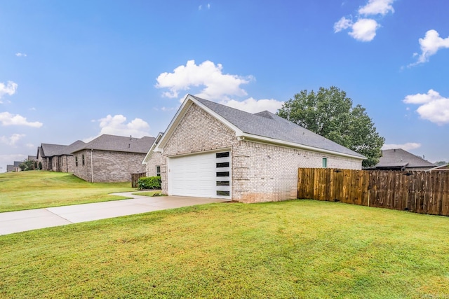 view of side of home with a yard, fence, concrete driveway, and brick siding