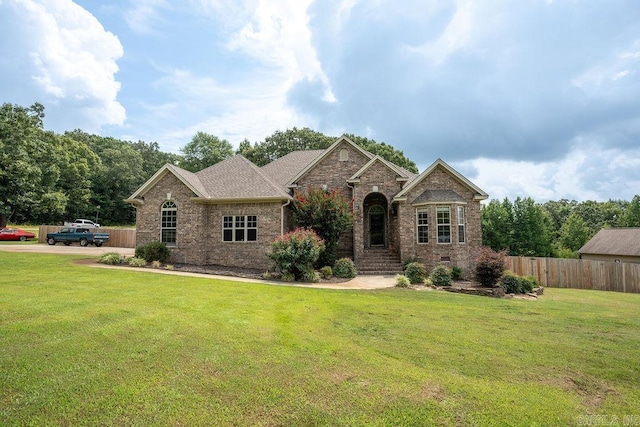 view of front of home with crawl space, brick siding, fence, and a front lawn