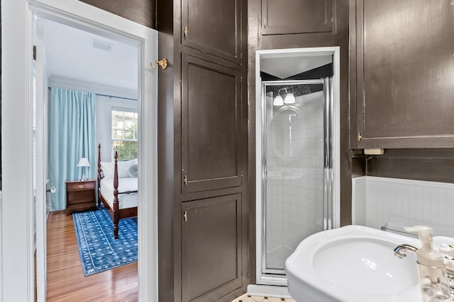 full bathroom with a stall shower, visible vents, connected bathroom, wood finished floors, and a sink