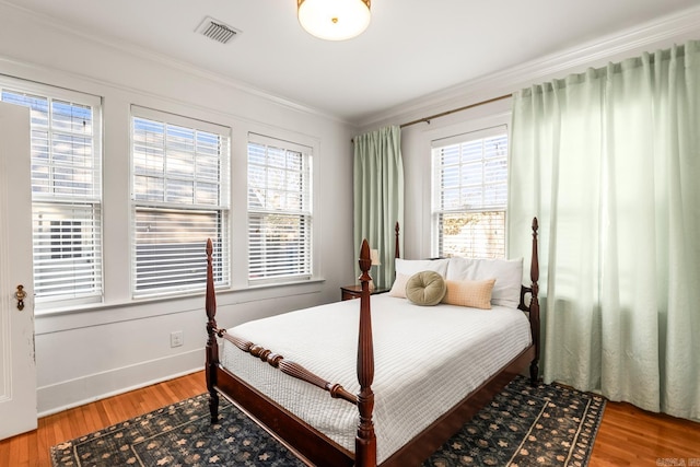 bedroom featuring multiple windows, visible vents, and wood finished floors