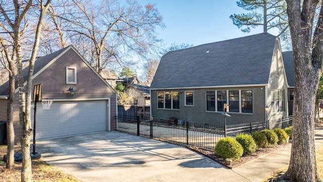 view of front of property with brick siding, a fenced front yard, and a detached garage