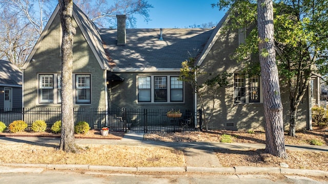 view of front facade featuring a fenced front yard, crawl space, brick siding, and a chimney