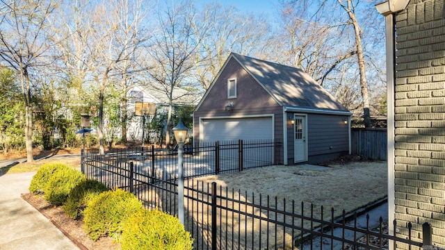 exterior space with a garage, an outbuilding, and fence