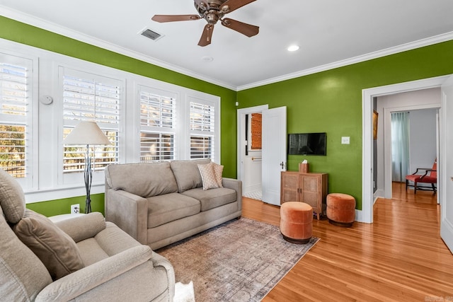 living area with visible vents, ceiling fan, crown molding, light wood-type flooring, and recessed lighting