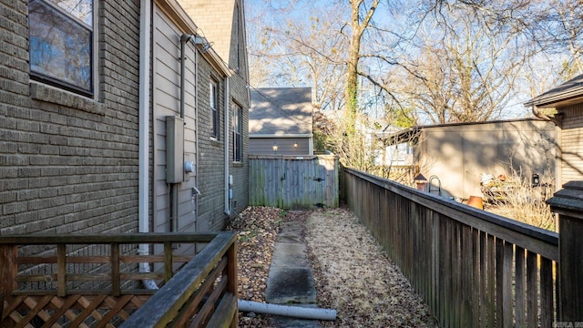 view of side of property with fence and brick siding