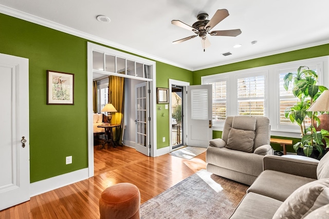 living room featuring wood finished floors, visible vents, and crown molding