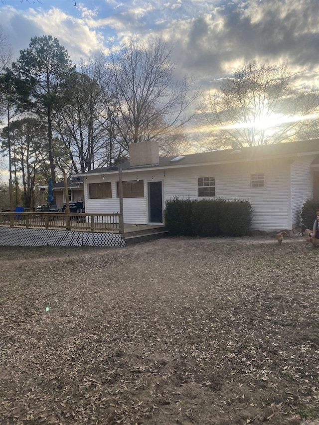 view of front facade with a chimney and a deck