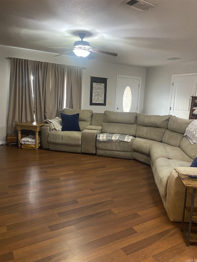 living room with ceiling fan, wood finished floors, and visible vents
