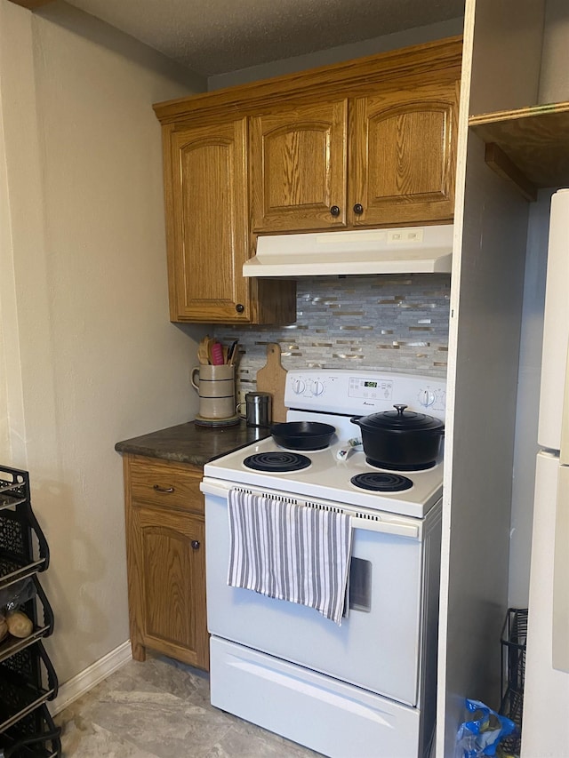 kitchen with under cabinet range hood, baseboards, decorative backsplash, brown cabinets, and white range with electric cooktop
