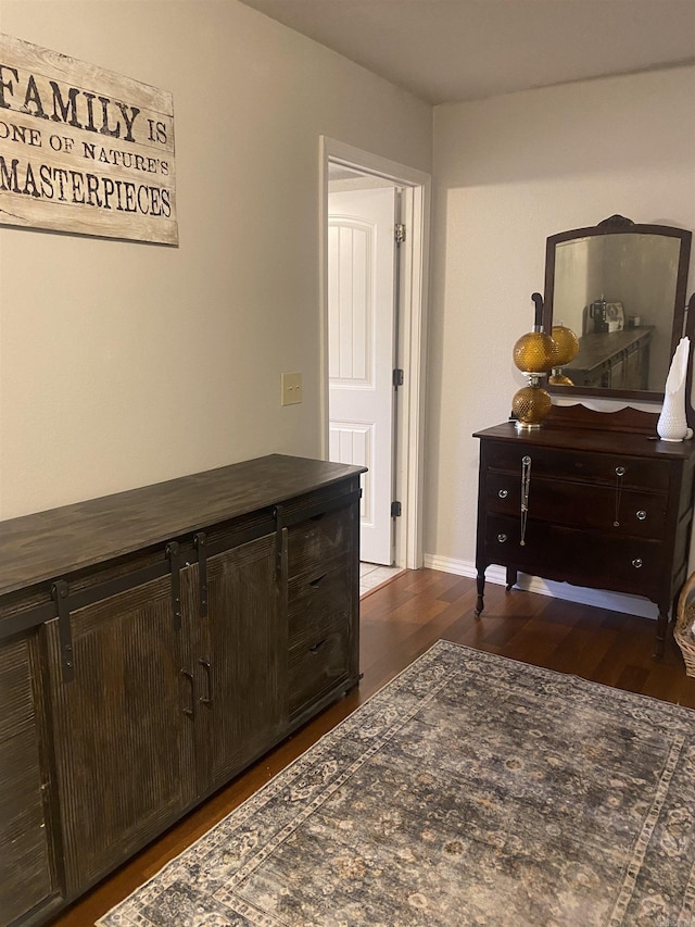 bedroom with dark wood-style flooring and baseboards