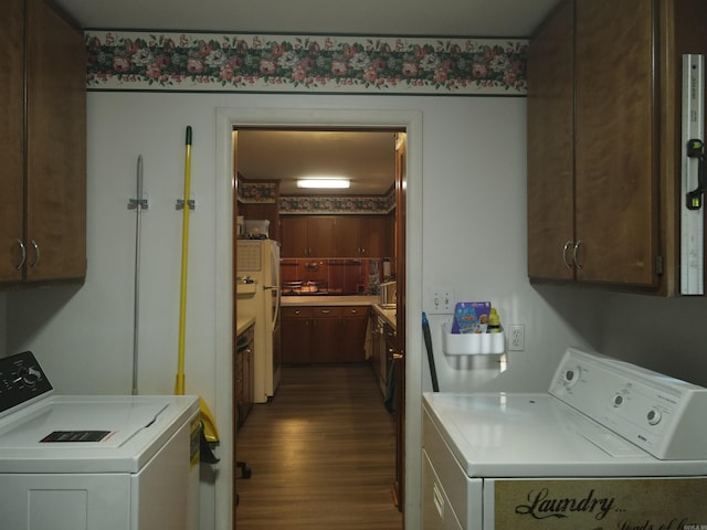 washroom with washing machine and clothes dryer, cabinet space, and dark wood finished floors