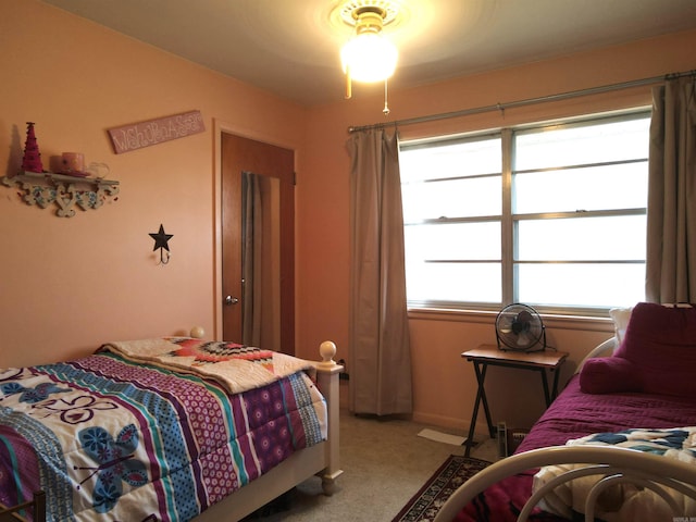 bedroom with multiple windows and light colored carpet