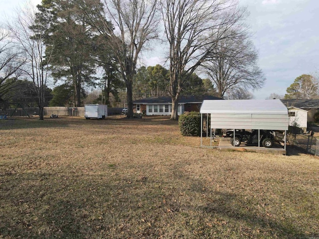 view of yard with a detached carport and fence