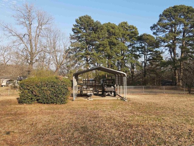 view of yard with a detached carport and fence