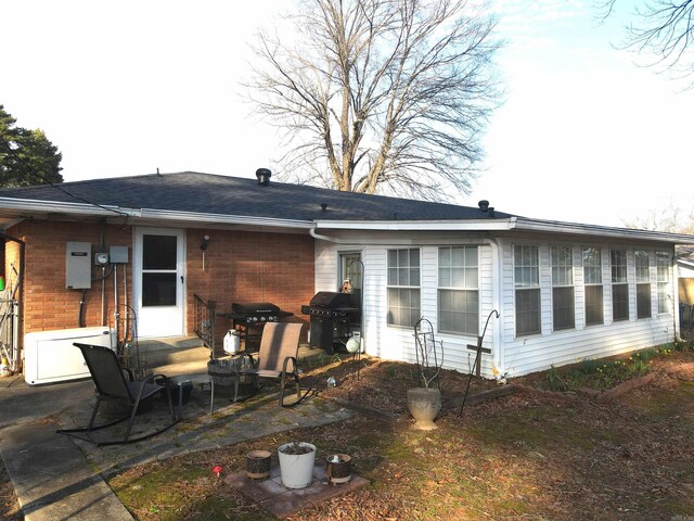 rear view of property with a patio and brick siding