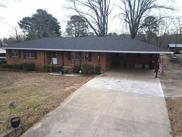 single story home with brick siding, roof with shingles, and driveway