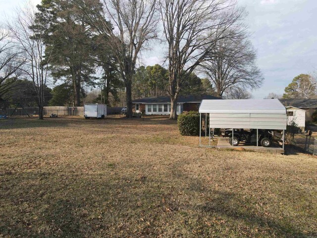 view of yard with a detached carport and fence