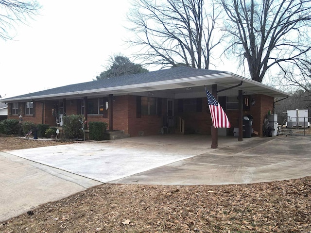 view of front of house featuring an attached carport, concrete driveway, and brick siding