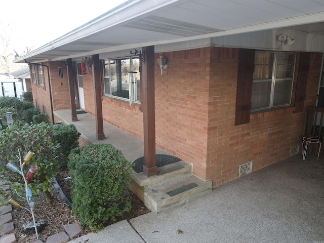 view of exterior entry with brick siding