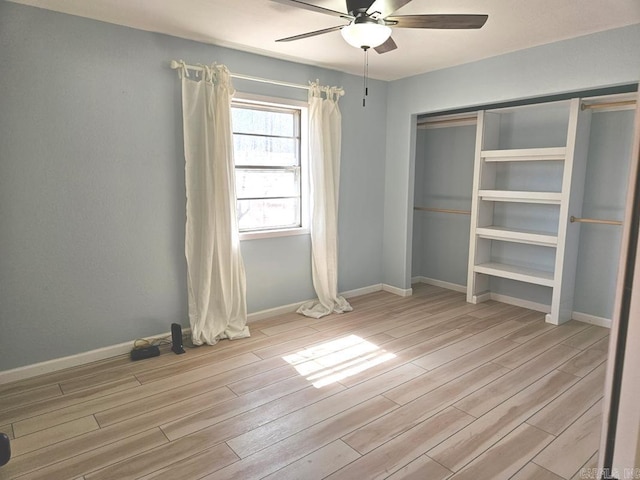 unfurnished bedroom with ceiling fan, a closet, wood finished floors, and baseboards