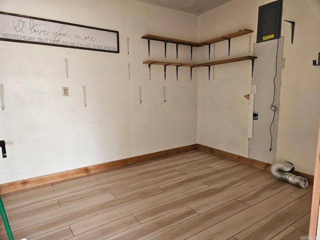 interior space featuring light wood-style floors, electric panel, and baseboards