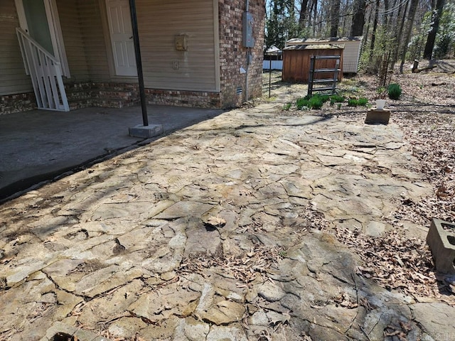 view of patio with an outbuilding and a storage unit